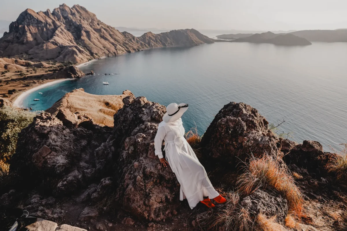 Woman staring off cliff of Oman shoreline