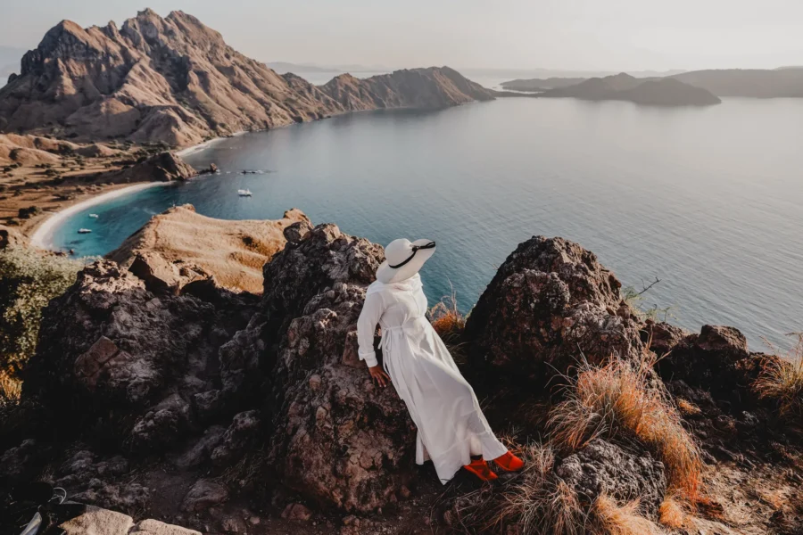 Woman staring off cliff of Oman shoreline